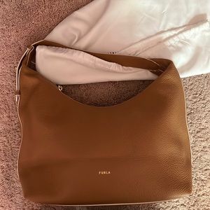 This is a Furla hobo bag the strap is adjustable.